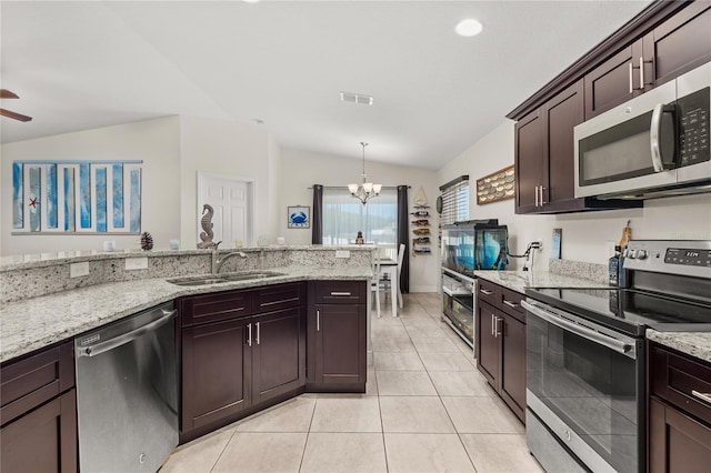 825 Desmoines Pl, Kissimmee, FL 34759 - kitchen with appliances with stainless steel finishes, a sink, a chandelier, vaulted ceiling, and light tile patterned floors