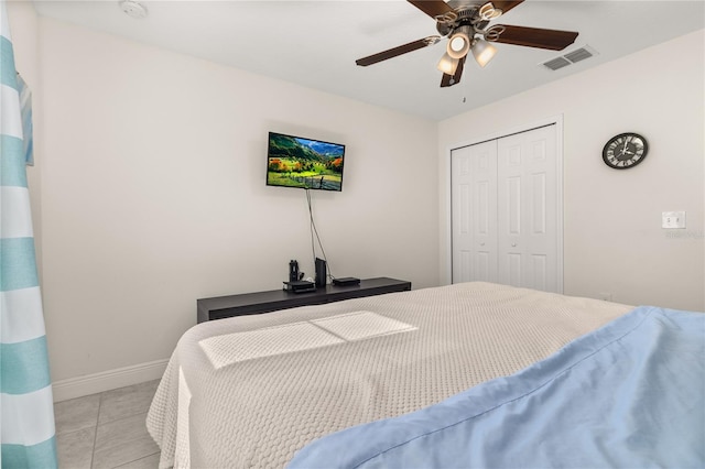 tiled bedroom featuring ceiling fan and a closet