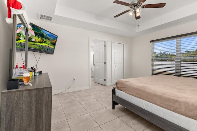 825 Desmoines Pl, Kissimmee, FL 34759 - bedroom with a tray ceiling, light tile patterned floors, baseboards, and ceiling fan