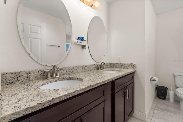 825 Desmoines Pl, Kissimmee, FL 34759 - bathroom with toilet, double vanity, tile patterned floors, and baseboards