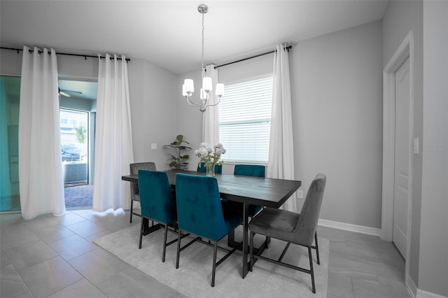 dining space with ceiling fan with notable chandelier and light tile patterned flooring