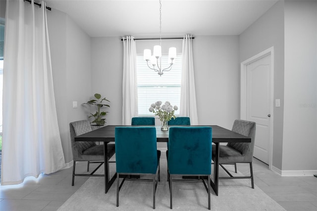 tiled dining room with a chandelier