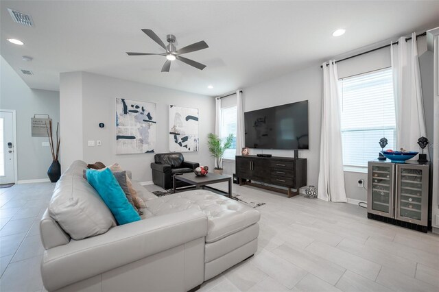 living room with plenty of natural light, ceiling fan, and beverage cooler