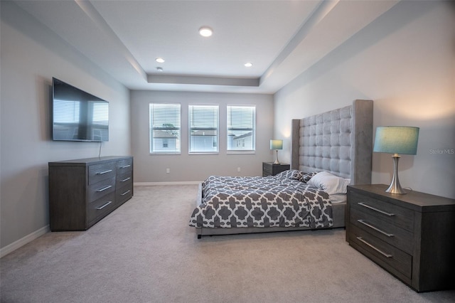 carpeted bedroom featuring a raised ceiling