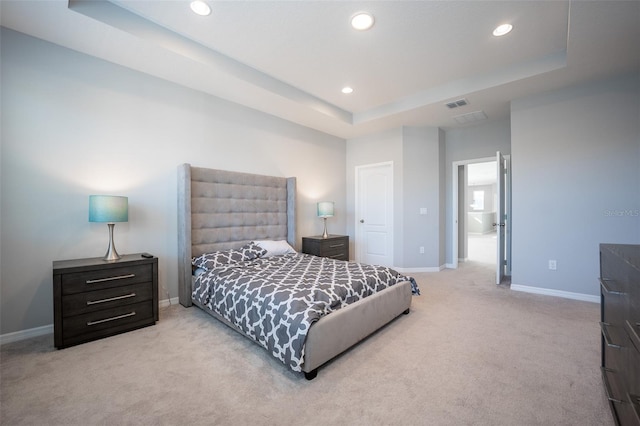 carpeted bedroom with a tray ceiling