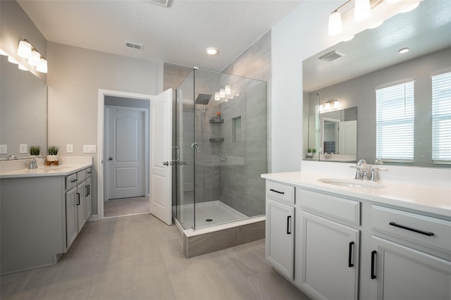 bathroom with vanity, an enclosed shower, and a textured ceiling