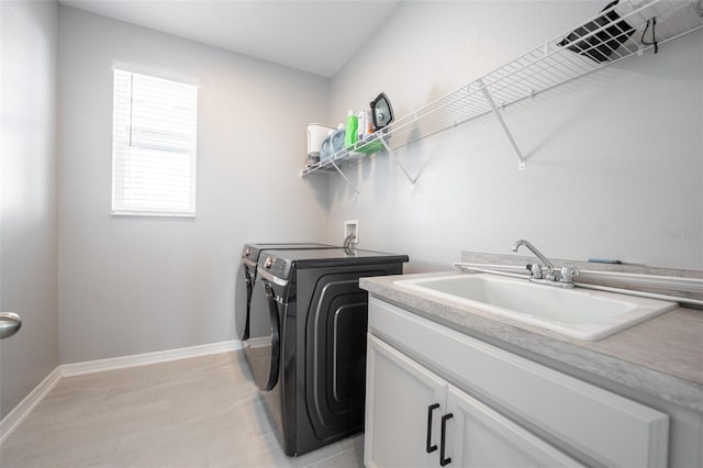 laundry area with separate washer and dryer, sink, and cabinets