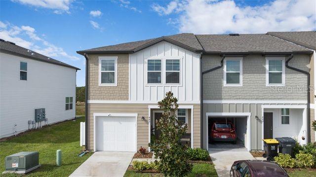 view of front of house featuring a garage, central air condition unit, and a front yard