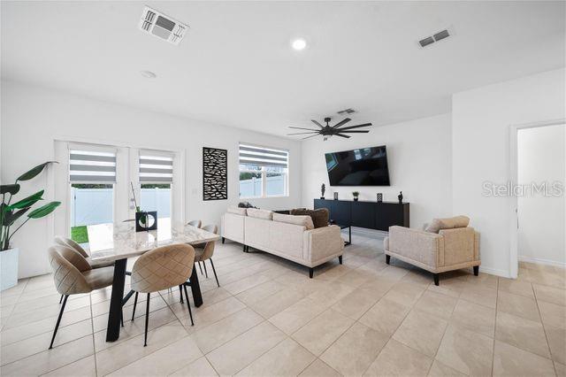 tiled living room with ceiling fan