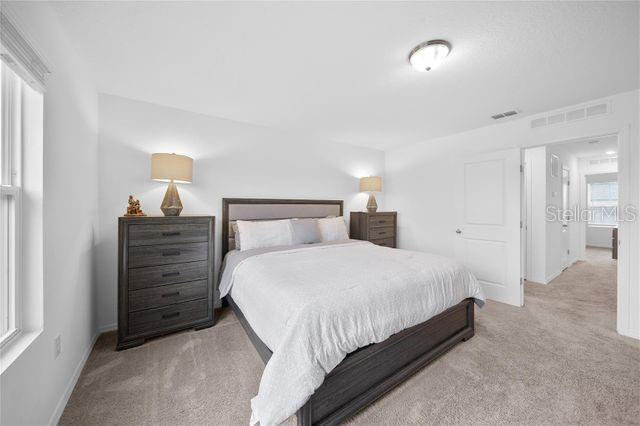 carpeted bedroom featuring multiple windows