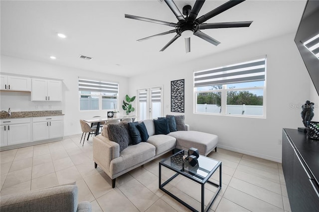 living room featuring ceiling fan, sink, and light tile patterned flooring