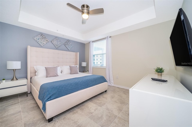 bedroom with a raised ceiling and ceiling fan