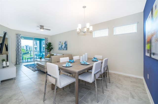 tiled dining area with ceiling fan with notable chandelier and a wealth of natural light