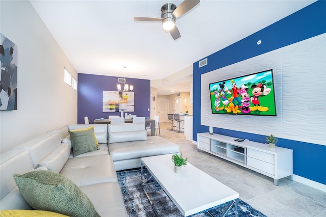 living room with ceiling fan with notable chandelier