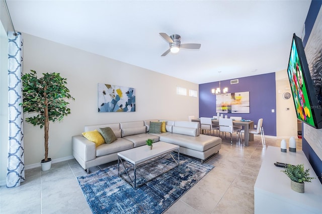 tiled living room featuring ceiling fan with notable chandelier