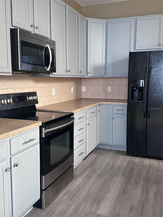 kitchen featuring light hardwood / wood-style floors, white cabinetry, and appliances with stainless steel finishes