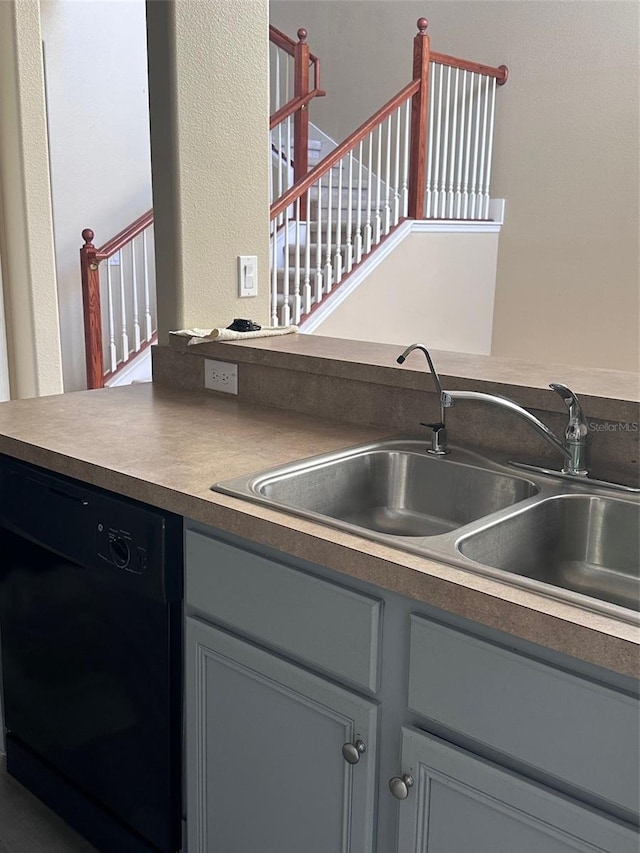 kitchen featuring black dishwasher, gray cabinetry, and sink