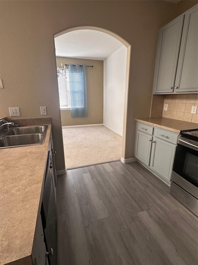 kitchen with backsplash, dark hardwood / wood-style flooring, sink, and appliances with stainless steel finishes