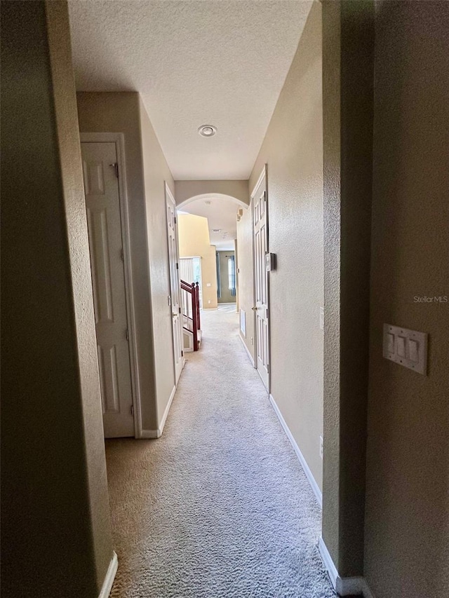 hallway featuring light colored carpet