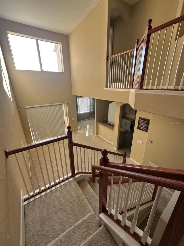 staircase with carpet flooring and a high ceiling