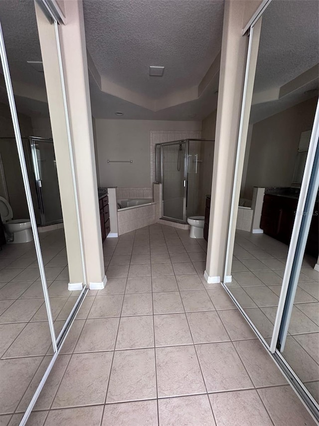 bathroom featuring a textured ceiling, a shower with door, a bidet, tile patterned flooring, and toilet