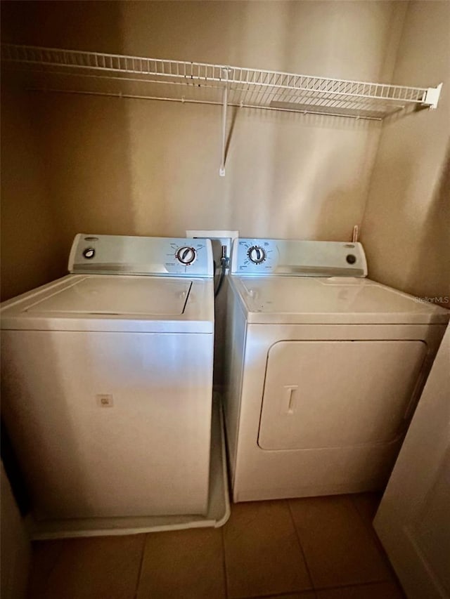 clothes washing area with tile patterned floors and independent washer and dryer