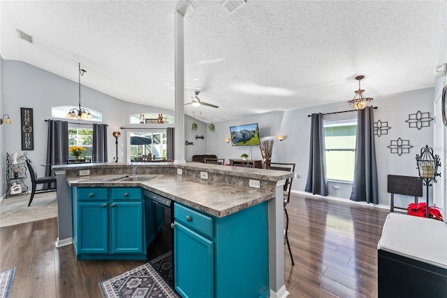 kitchen featuring a center island, blue cabinets, vaulted ceiling, and hanging light fixtures