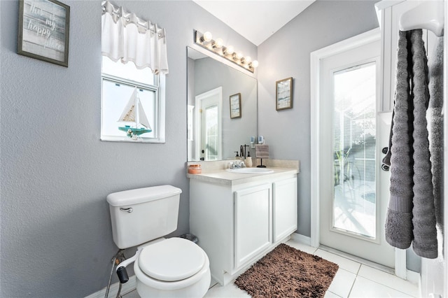 bathroom with toilet, vanity, and tile patterned floors