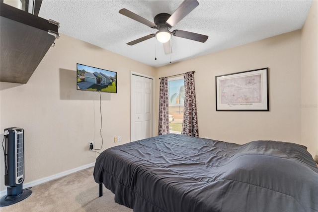 bedroom featuring light carpet, a textured ceiling, a closet, and ceiling fan