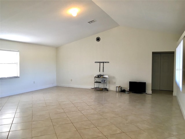 unfurnished living room with light tile patterned floors and vaulted ceiling