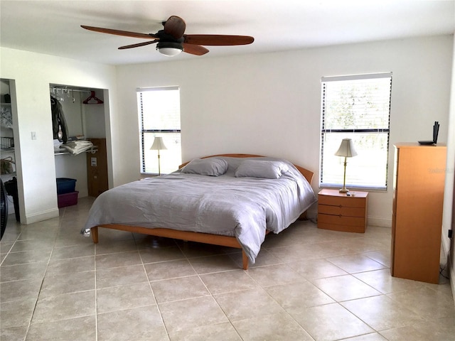 tiled bedroom with a closet, multiple windows, and ceiling fan