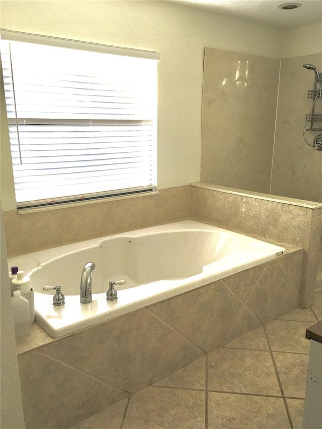 bathroom with tile patterned floors and a relaxing tiled tub