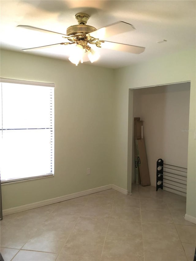 unfurnished room with light tile patterned floors and ceiling fan