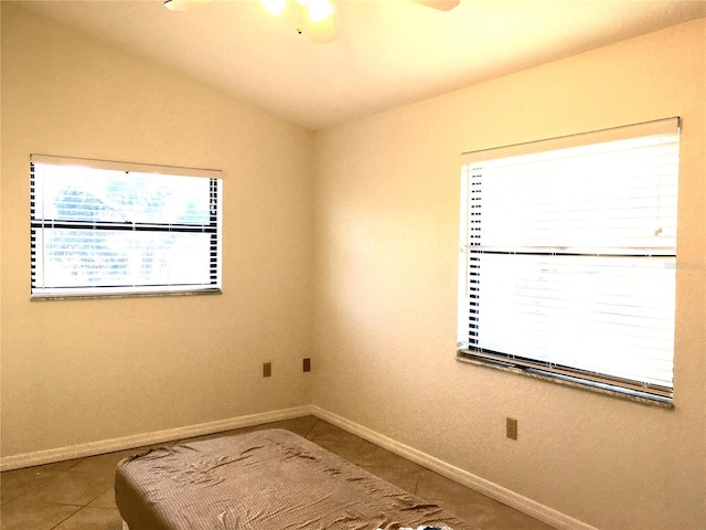 empty room featuring vaulted ceiling and tile patterned floors