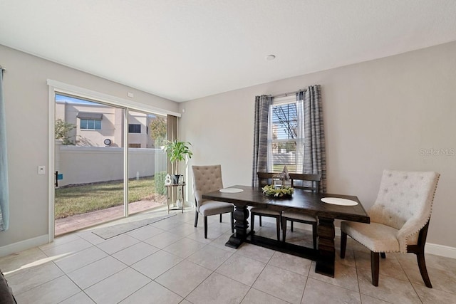 dining room with light tile patterned floors and baseboards