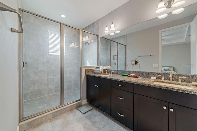 full bath featuring connected bathroom, a sink, a shower stall, and double vanity