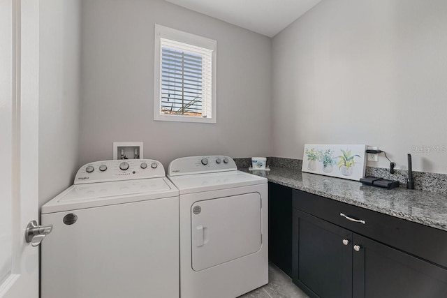 laundry area featuring washer and dryer, light tile patterned floors, and cabinets