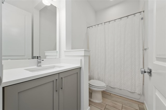 full bathroom with vanity, wood-type flooring, shower / bath combo, and toilet