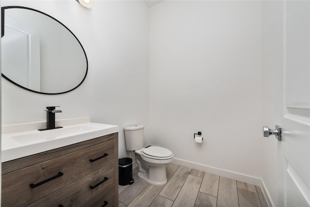 bathroom featuring vanity, toilet, and wood-type flooring