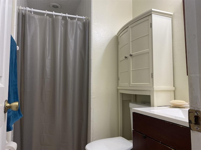 bathroom with curtained shower, vanity, a textured ceiling, and toilet