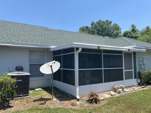 view of home's exterior with a sunroom and central air condition unit