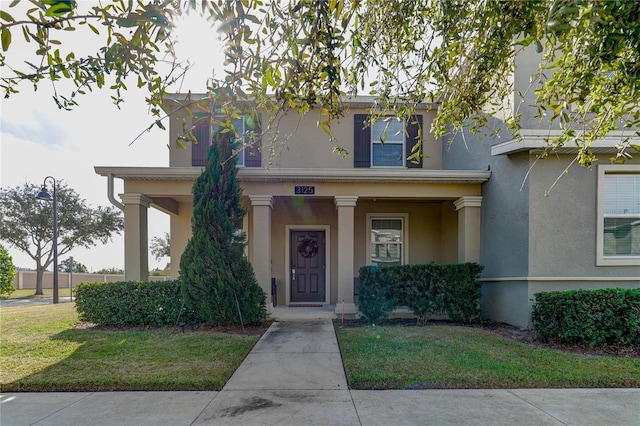 view of front of house with a front yard and covered porch