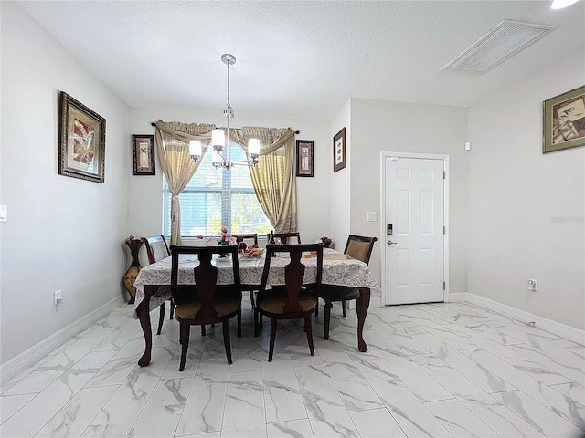 dining space with a textured ceiling and a notable chandelier