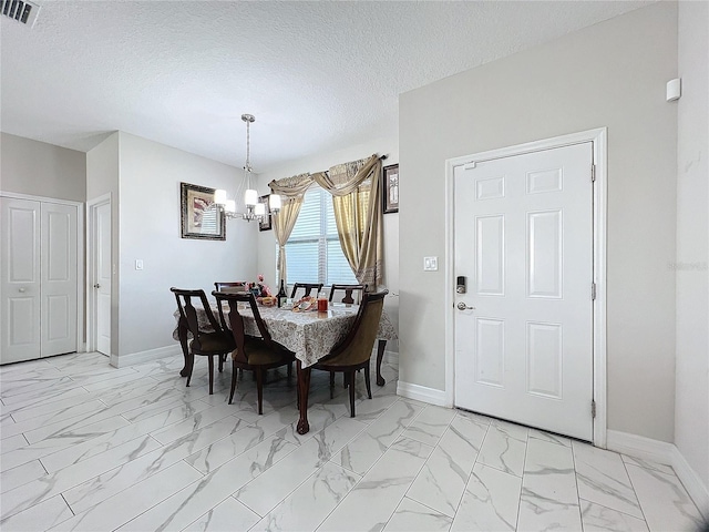 dining space featuring a textured ceiling and a chandelier