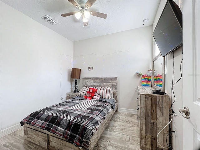 bedroom with a textured ceiling and ceiling fan