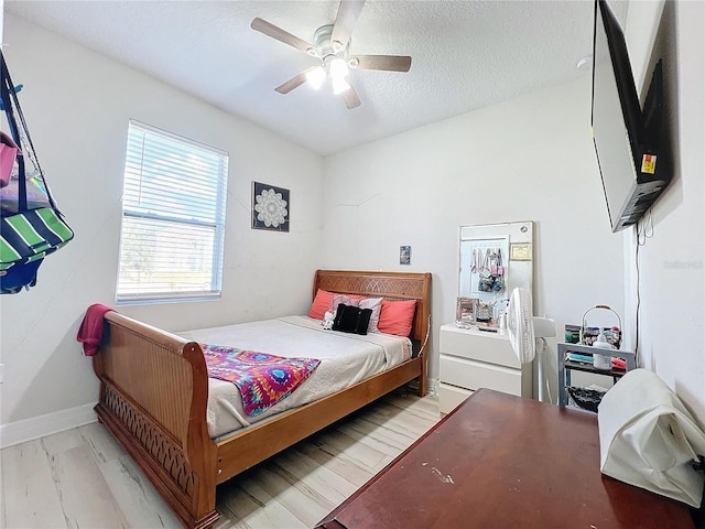 bedroom featuring a textured ceiling, light hardwood / wood-style floors, and ceiling fan