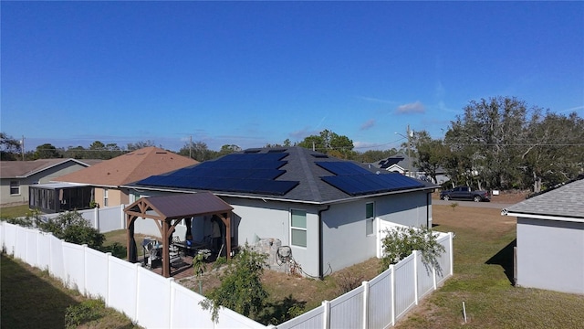 view of side of property featuring a gazebo, a yard, and solar panels