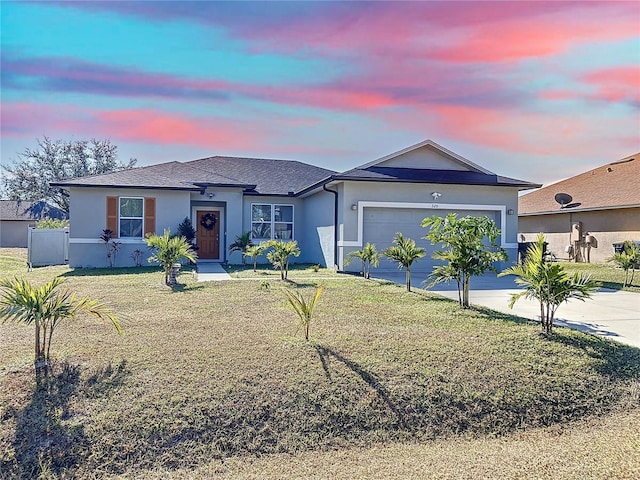 ranch-style house featuring a yard and a garage