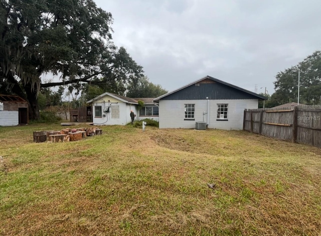 back of property with a yard and central air condition unit