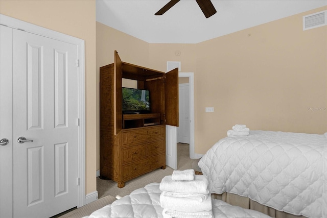 carpeted bedroom with ceiling fan and a closet